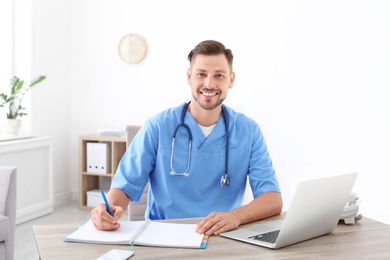 Photo of Male medical assistant at workplace in clinic. Health care service