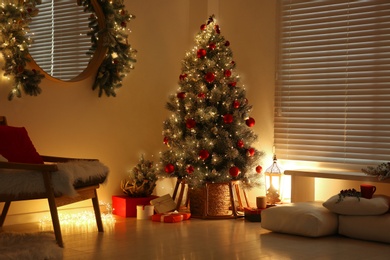 Beautiful decorated Christmas tree in festive room interior