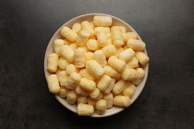 Photo of Plate of corn sticks on dark grey table, top view