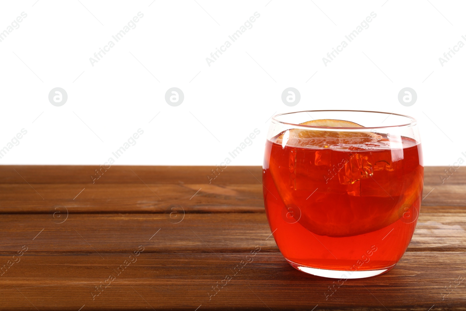 Photo of Aperol spritz cocktail and orange slices in glass on wooden table against white background