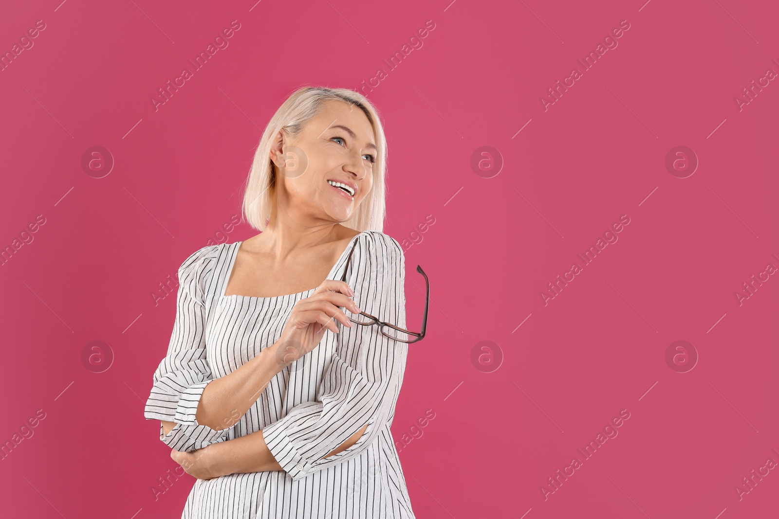 Photo of Portrait of beautiful mature woman with glasses on pink background. Space for text