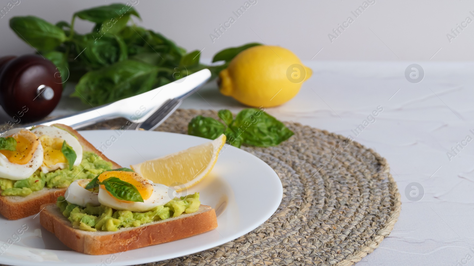 Photo of Tasty sandwiches with boiled egg, avocado and spinach on light grey textured table, closeup