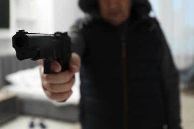 Photo of Dangerous criminal with gun in foreign house, selective focus. Armed robbery