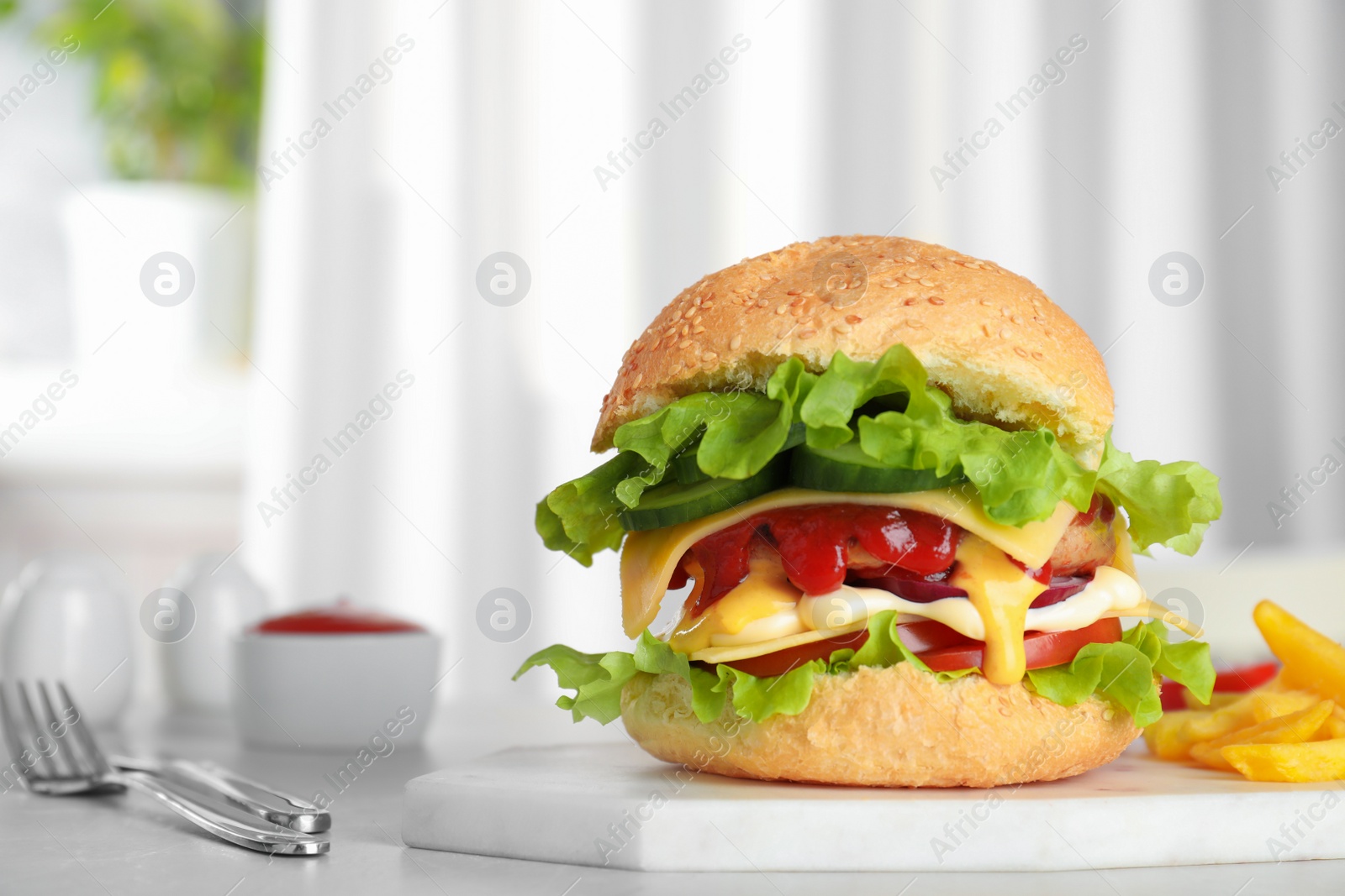 Photo of Board with tasty burger on table. Space for text