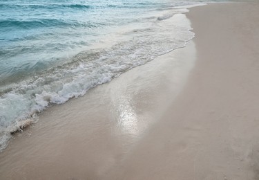 Sea waves rolling onto sandy tropical beach