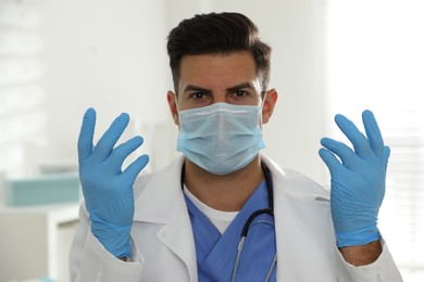 Photo of Doctor in protective mask and medical gloves against blurred background