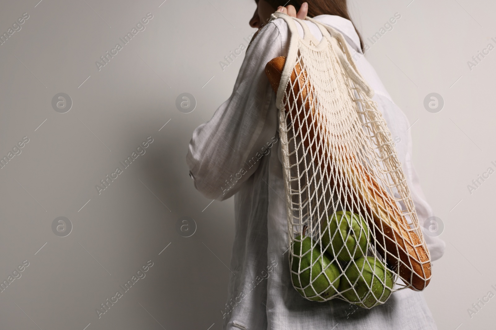 Photo of Woman with eco bag full of products on white background, closeup. Space for text