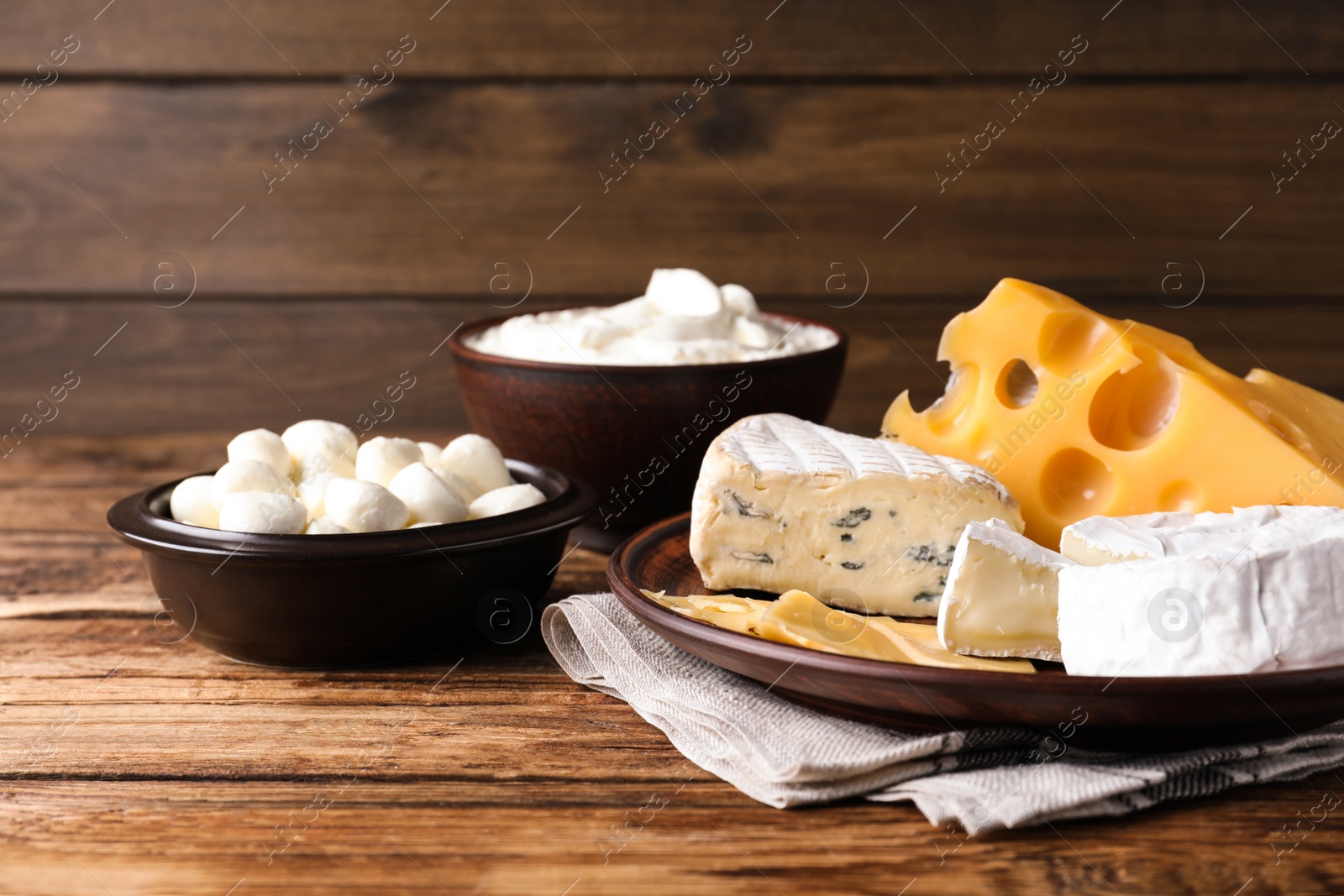 Photo of Composition with dairy products and clay dishware on wooden table