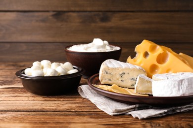Photo of Composition with dairy products and clay dishware on wooden table