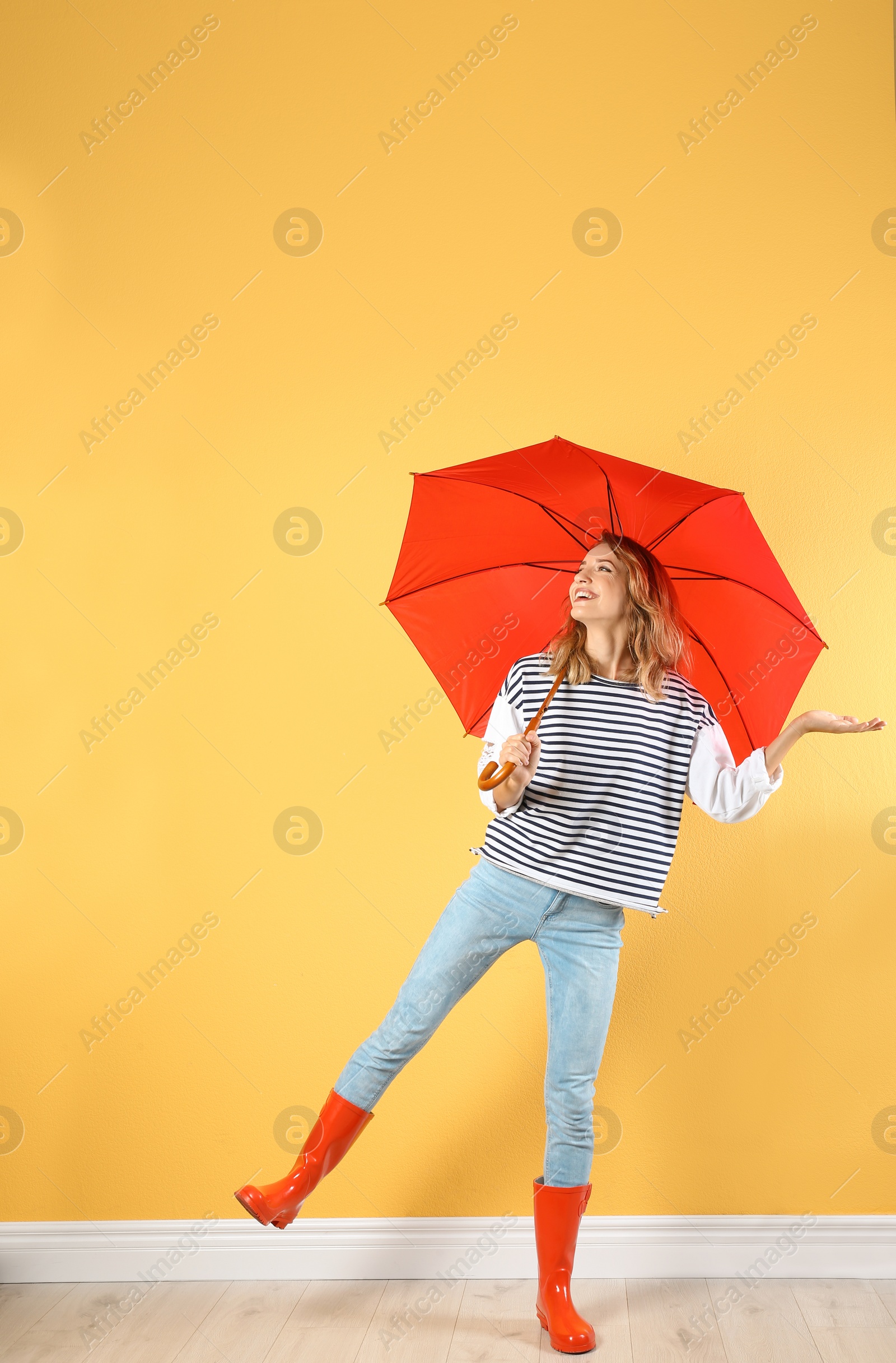 Photo of Woman with red umbrella near color wall