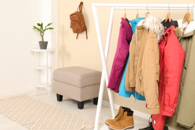 Photo of Stylish hallway interior with clothes on hanger stand