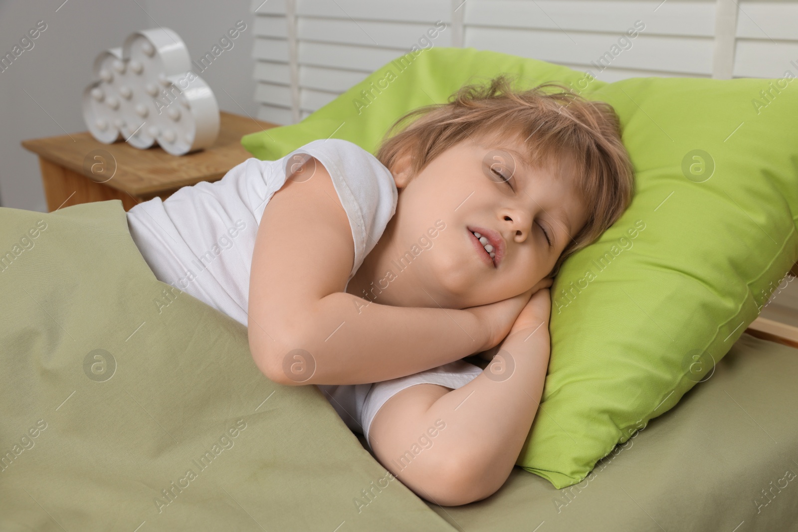 Photo of Little boy snoring while sleeping in bed indoors