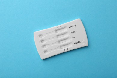 Disposable multi-infection express test on light blue background, top view