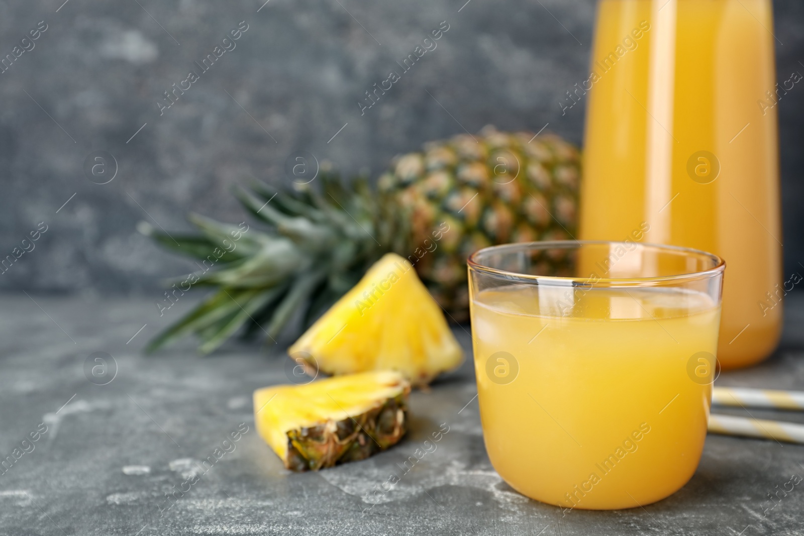 Photo of Glass with delicious pineapple juice on table