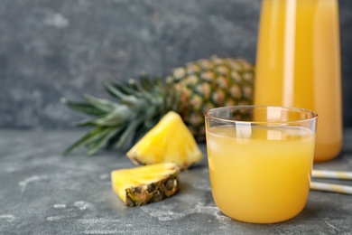 Photo of Glass with delicious pineapple juice on table