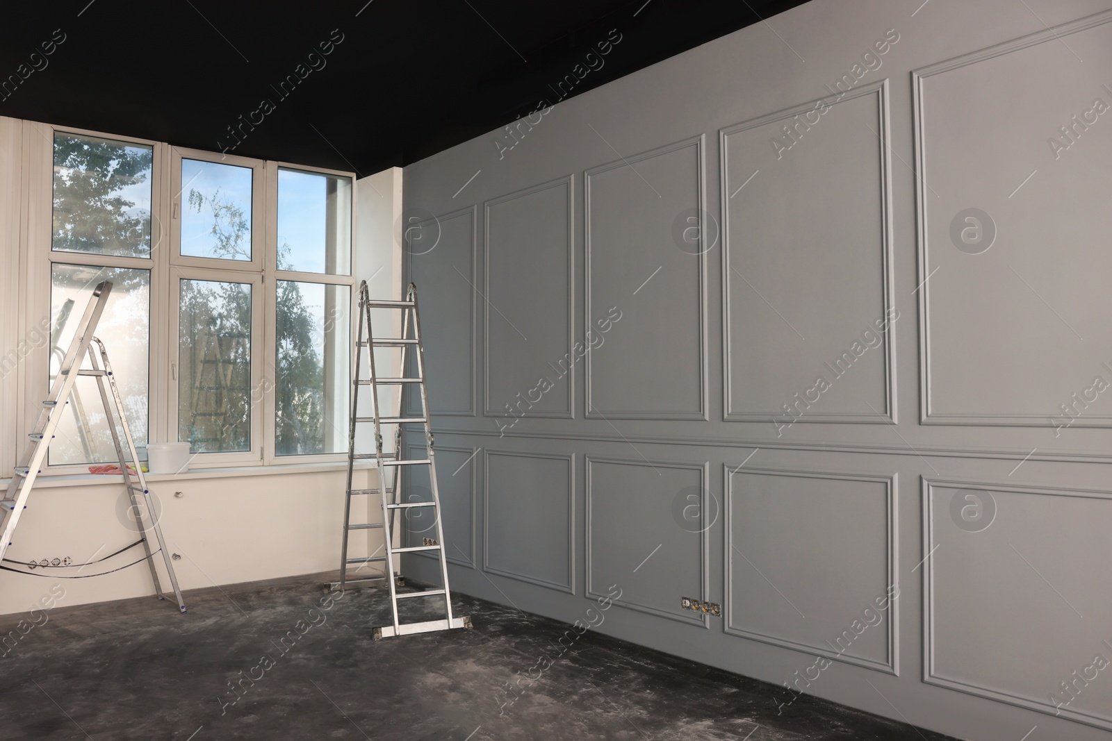 Photo of Metal ladders in empty room prepared for renovation