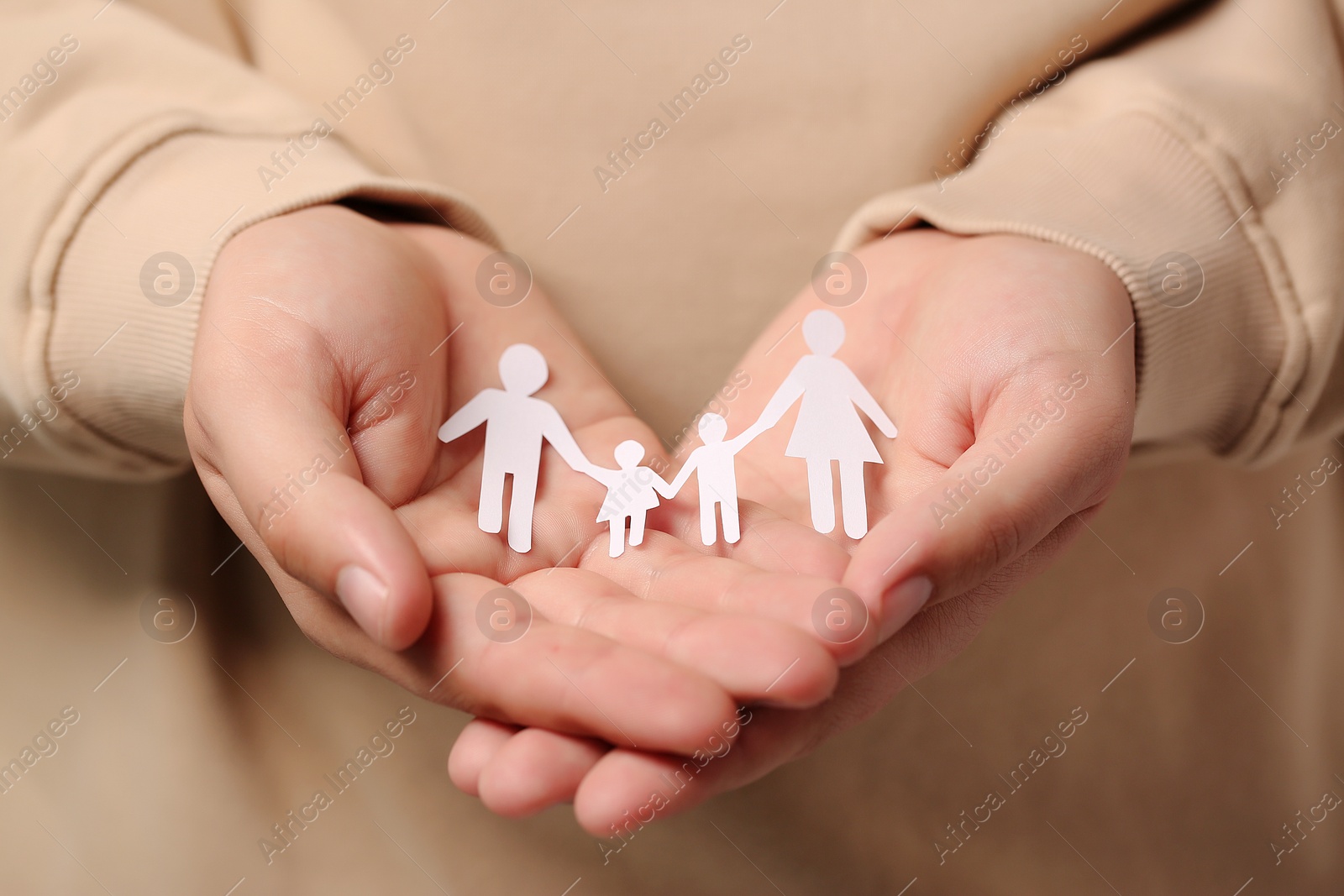 Photo of Man holding paper family figures, closeup. Insurance concept