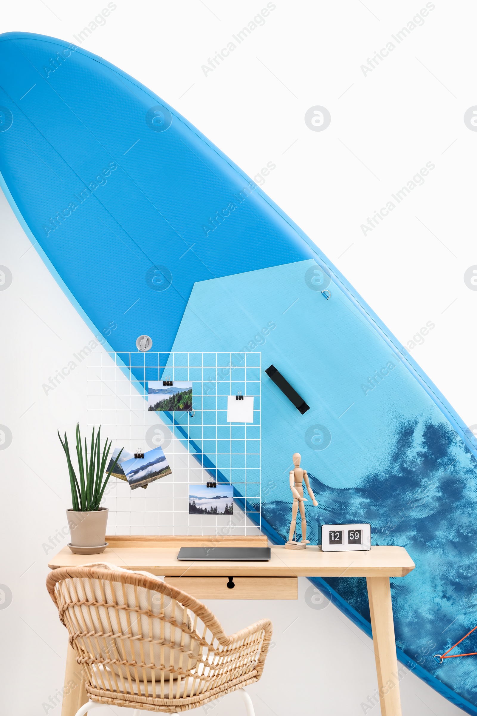 Photo of SUP board and workplace in room. Interior design