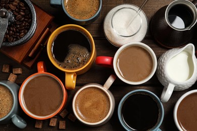 Cups of fresh aromatic coffee on wooden table, flat lay