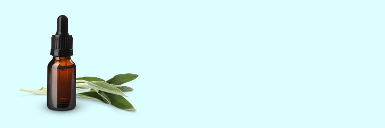 Image of Bottle of sage essential oil and green leaves on pale light blue background, space for text. Banner design