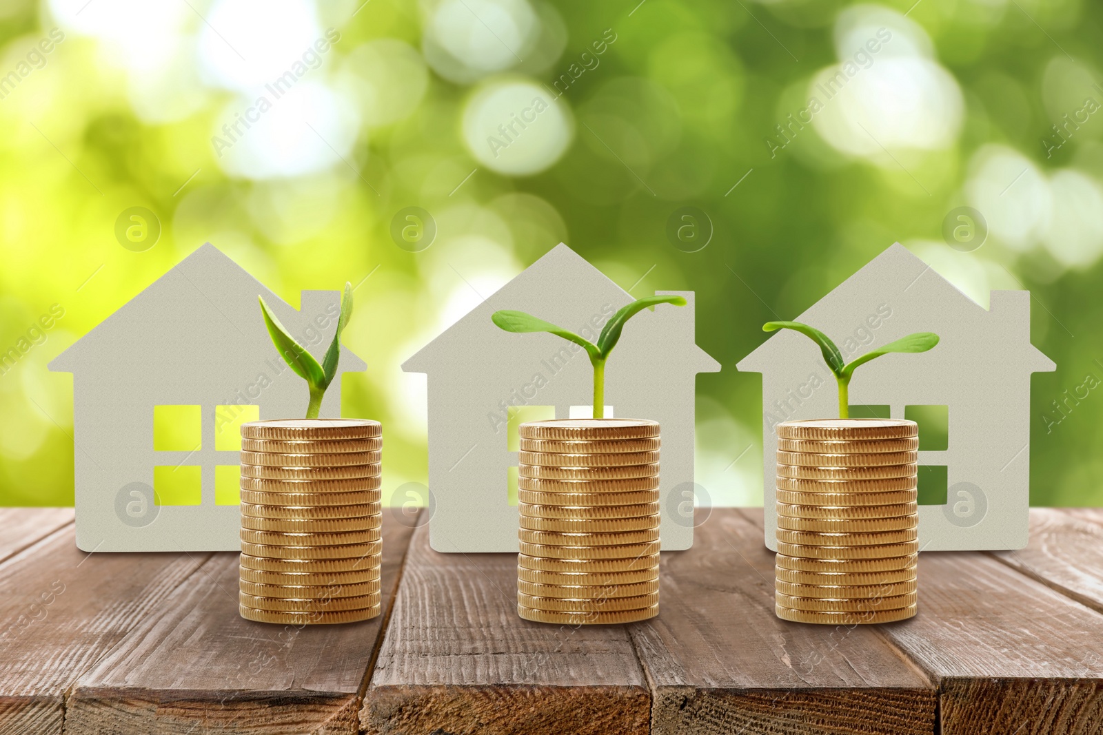 Image of Real estate investing. House models and coins on wooden table