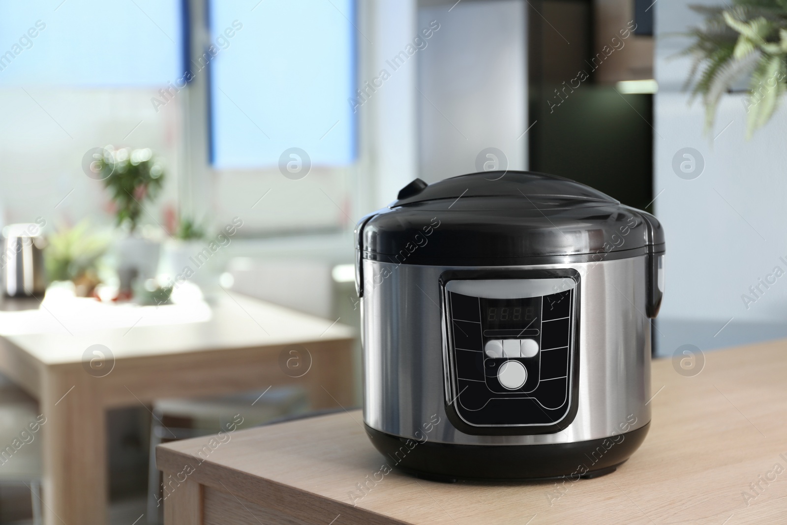 Photo of Modern multi cooker on table in kitchen. Space for text