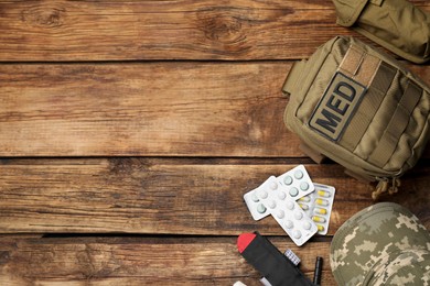 Photo of Military first aid kit on wooden table, flat lay. Space for text