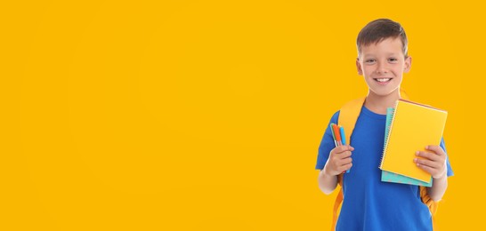 Image of Cute child with school stationery on yellow background, space for text. Banner design