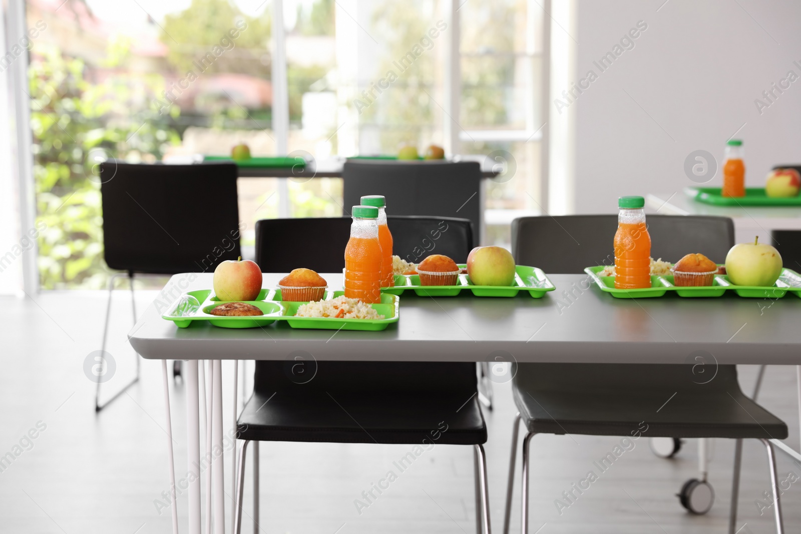 Photo of Trays with healthy food on table in school canteen