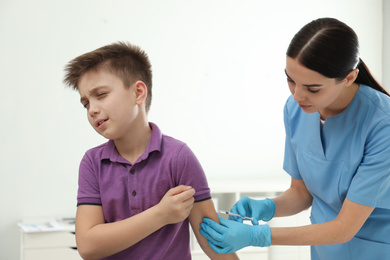 Photo of Doctor vaccinating little child in modern clinic