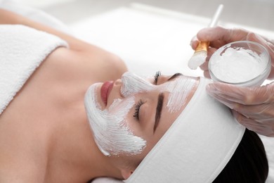 Photo of Young woman during face peeling procedure in salon