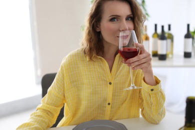 Woman with glass of wine at table in restaurant