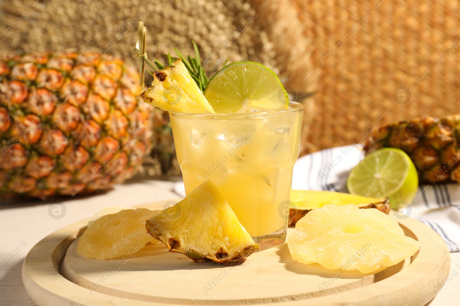 Photo of Glass of tasty pineapple cocktail and sliced fruits on table