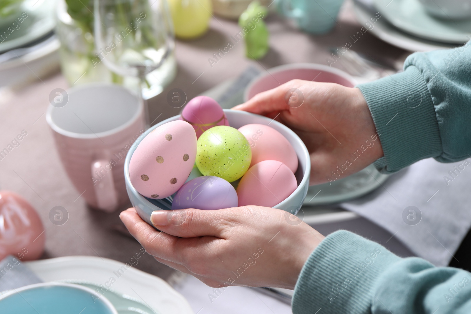 Photo of Woman setting table for festive Easter dinner at home, closeup