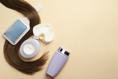 Photo of Natural cosmetic products, orchid flower, brush and hair lock on beige background, flat lay. Space for text
