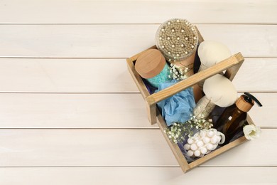 Spa gift set with different products in crate on white wooden table, top view. Space for text