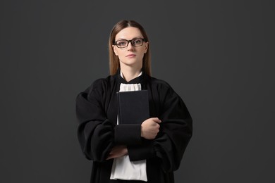 Photo of Portrait of judge with book on grey background