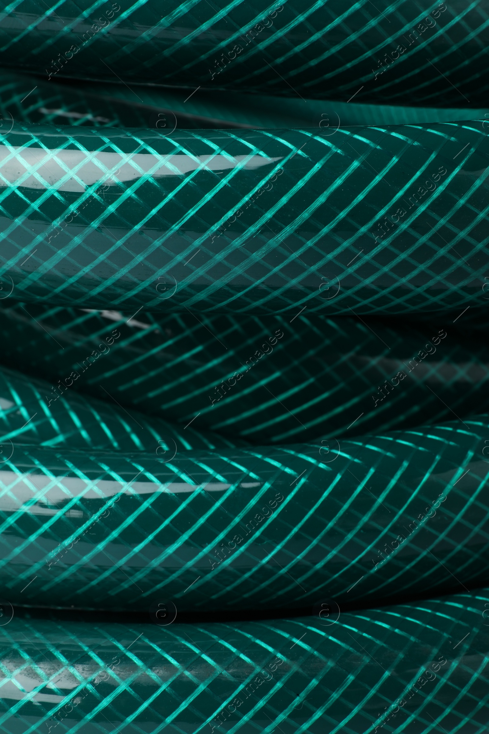 Photo of Green rubber watering hose as background, closeup