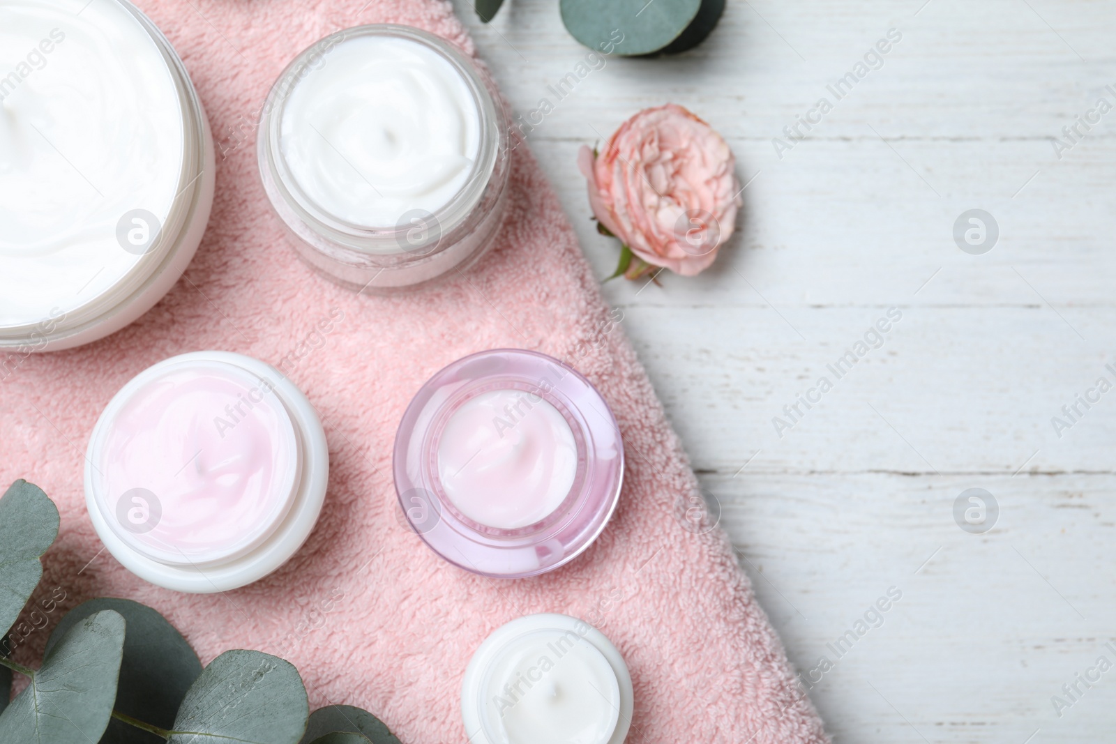 Photo of Flat lay composition with jars of cream on white wooden table