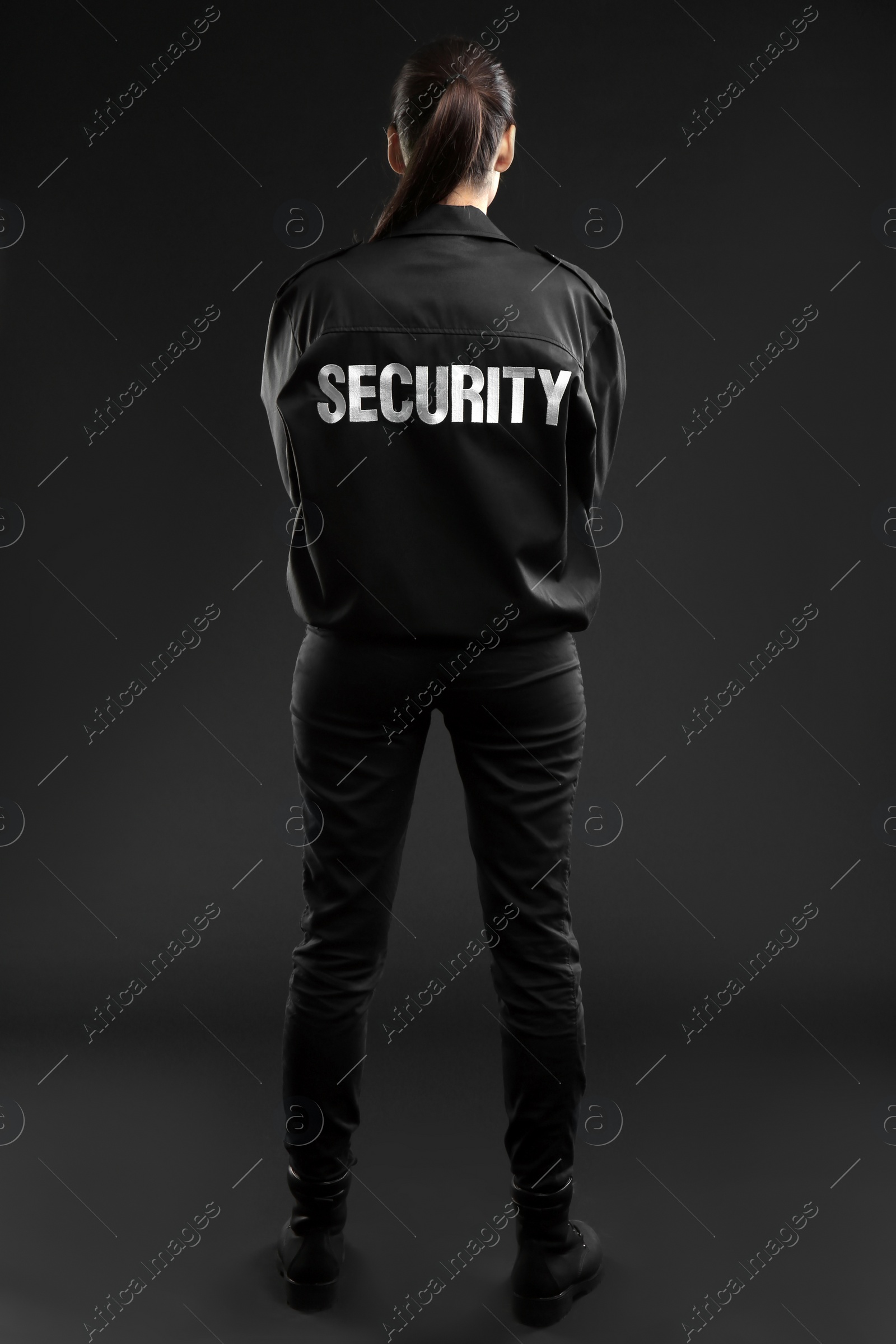 Photo of Female security guard in uniform on dark background