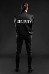 Female security guard in uniform on dark background