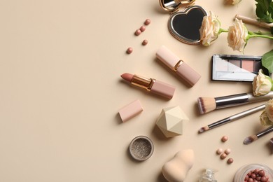 Flat lay composition with makeup products and beautiful roses on beige background, space for text