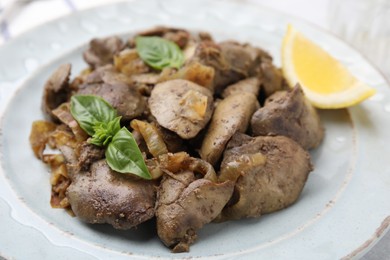 Delicious fried chicken liver with onion and basil on table, closeup
