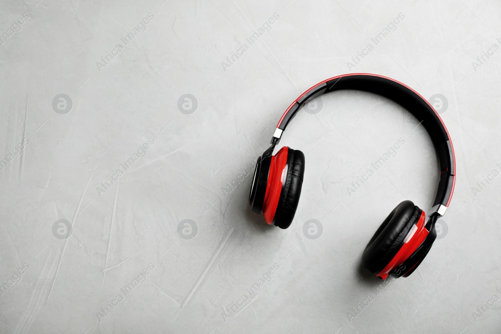 Photo of Stylish modern headphones and space for text on gray background, top view