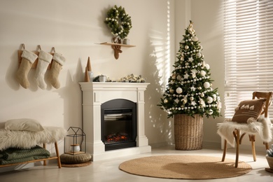 Photo of Beautiful living room interior with decorated Christmas tree and modern fireplace