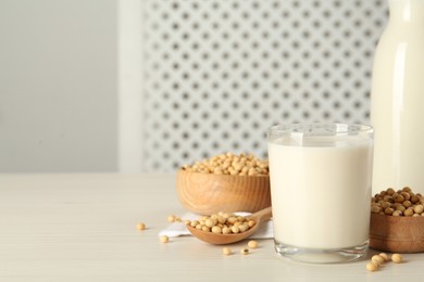 Soy milk and beans on wooden table, space for text