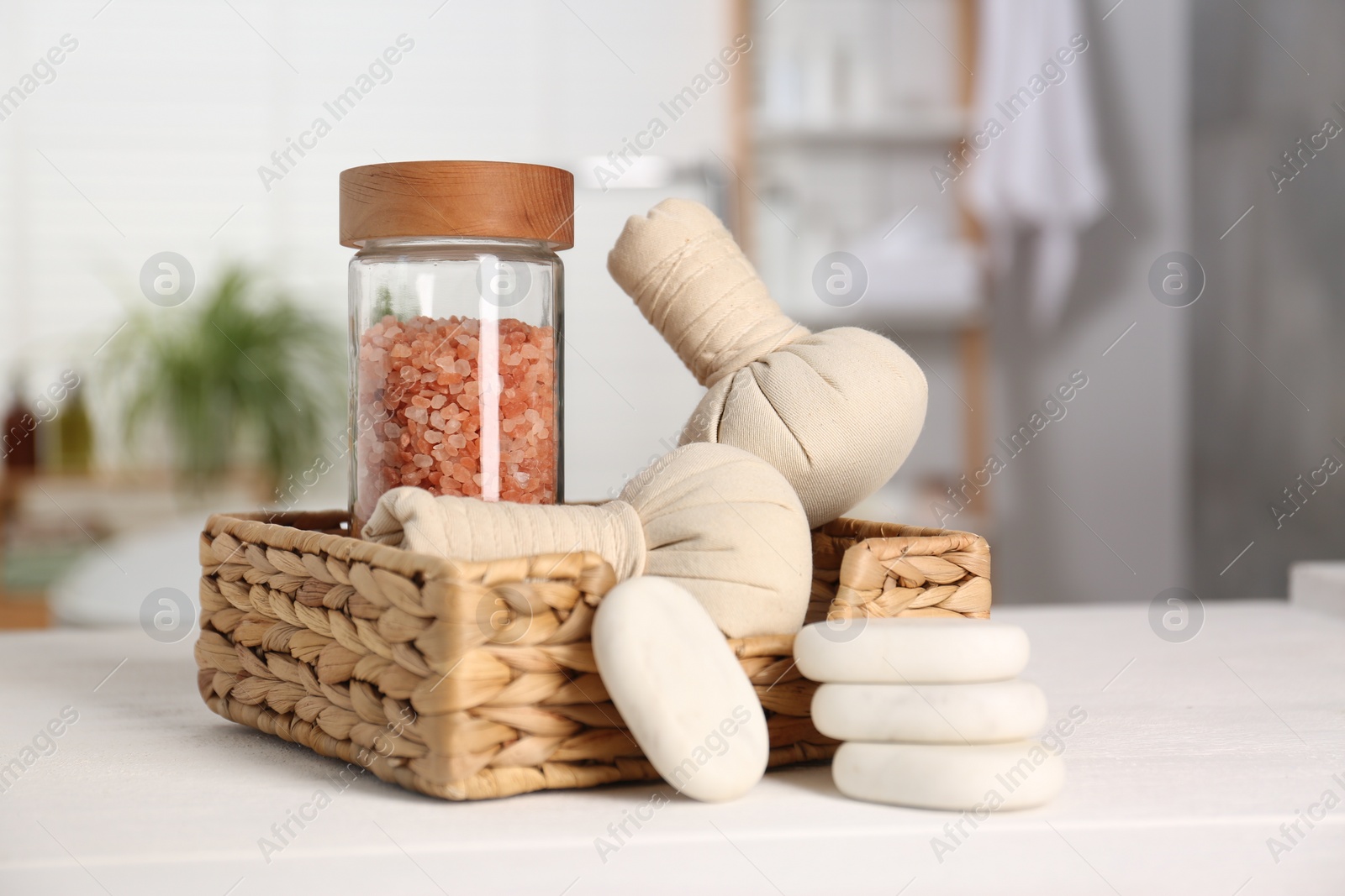 Photo of Composition with spa herbal bags on white wooden table in bathroom, closeup