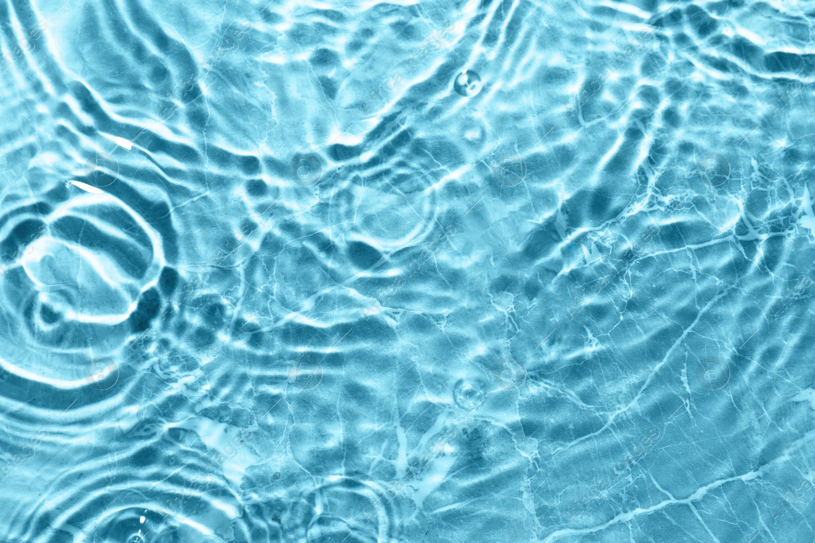 Image of Rippled surface of clear water on light blue background, top view