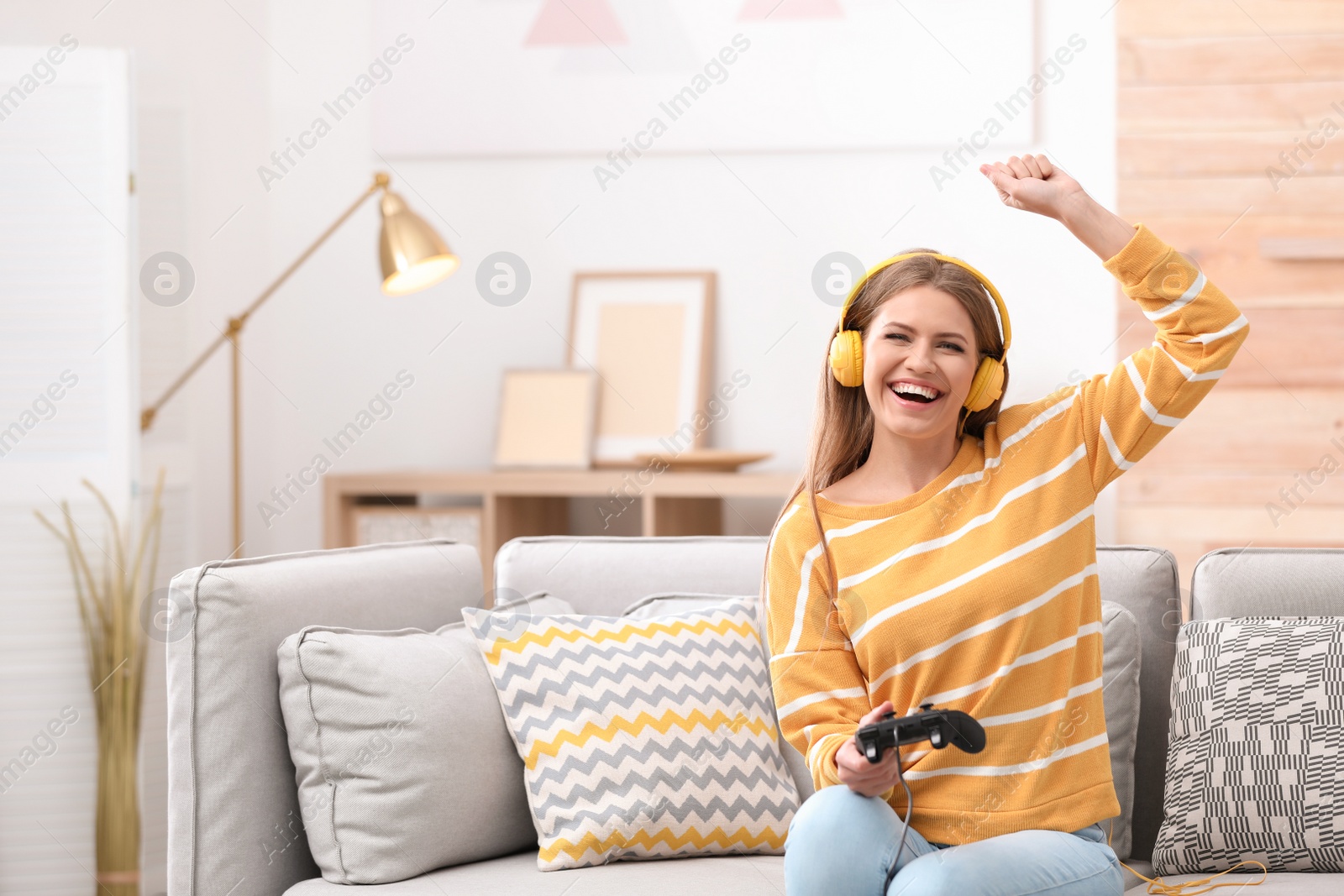 Photo of Emotional young woman playing video games at home