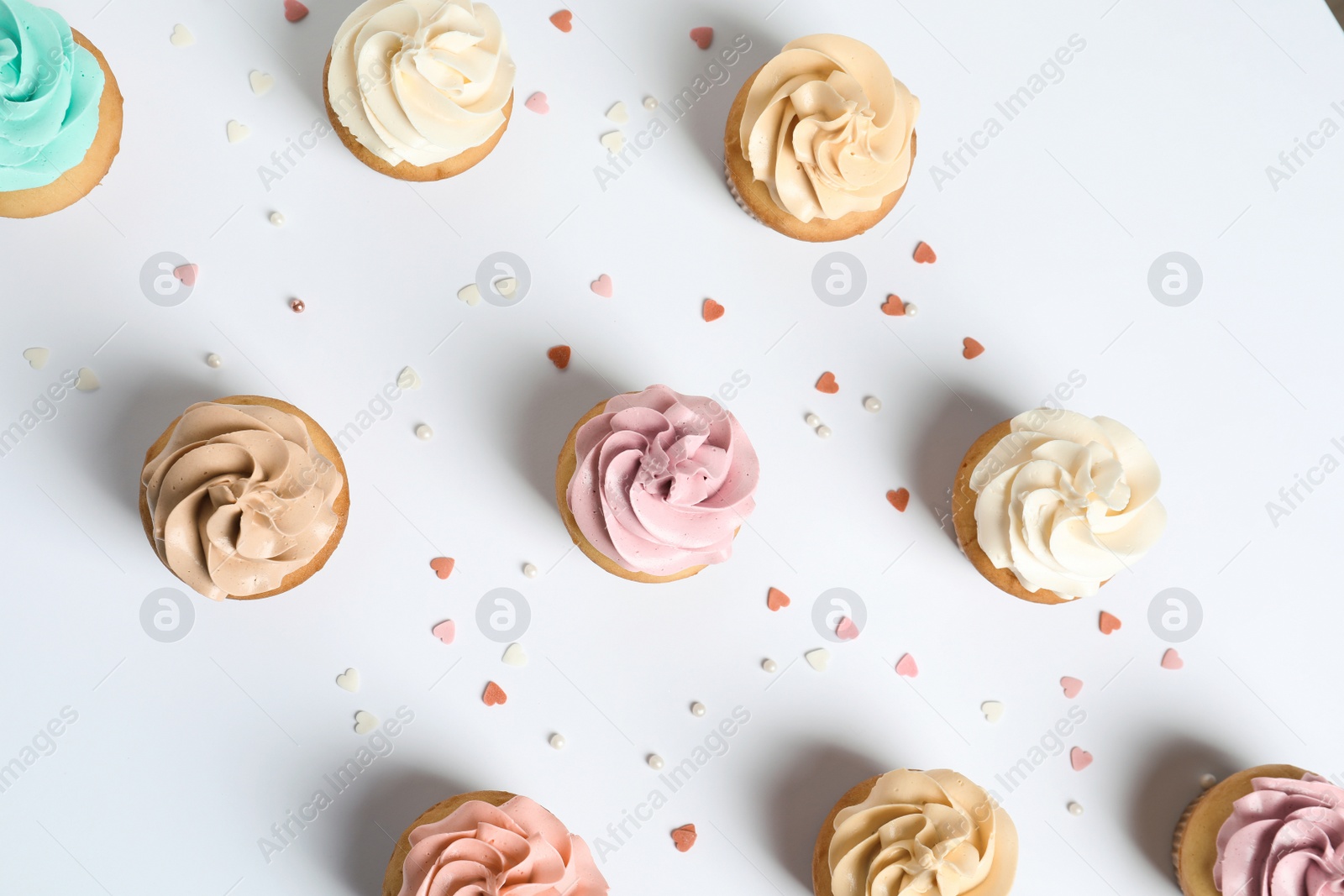 Photo of Flat lay composition with delicious birthday cupcakes on white background
